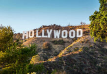 Hollywood Sign on a green hillside, sunny day.