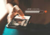 A hand holding a smartphone displaying a love loading screen