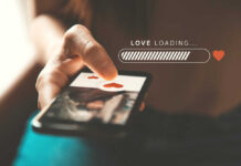 A hand holding a smartphone displaying a love loading screen