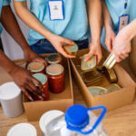 Volunteers organizing canned goods and jars for a food donation