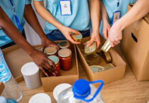 Volunteers organizing canned goods and jars for a food donation