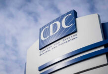 CDC building sign against a cloudy sky.