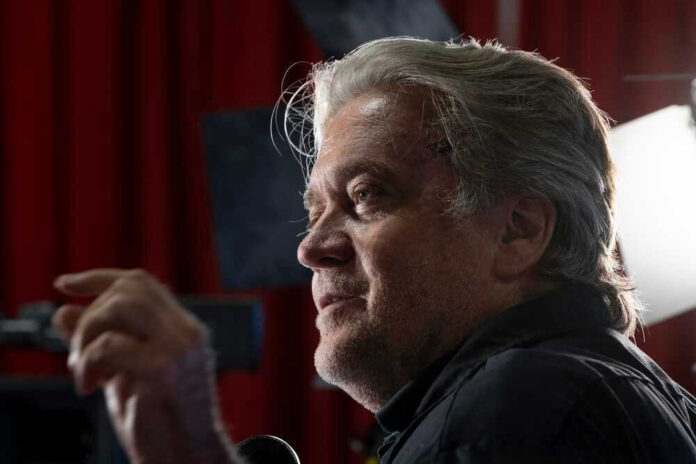 Person speaking in front of bright lights and red curtain.
