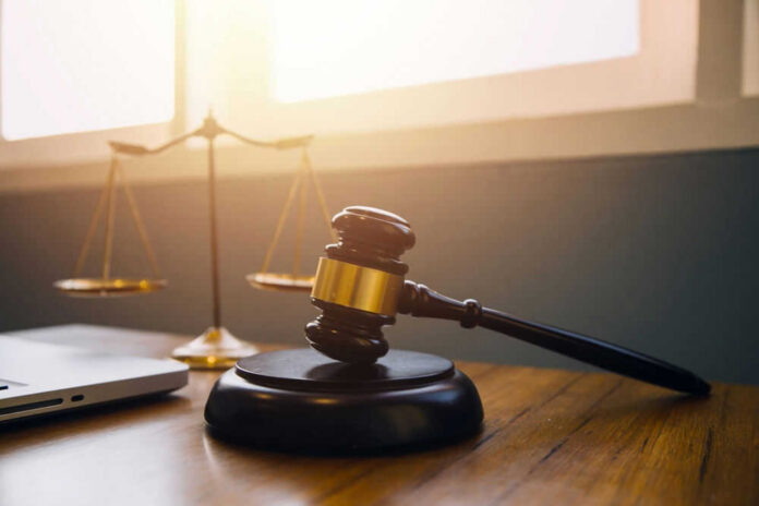 shutterstock_2347797923.jpg Gavel and scales of justice on desk.