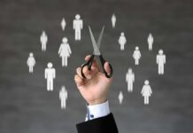 A hand holding scissors with icons of people in the background