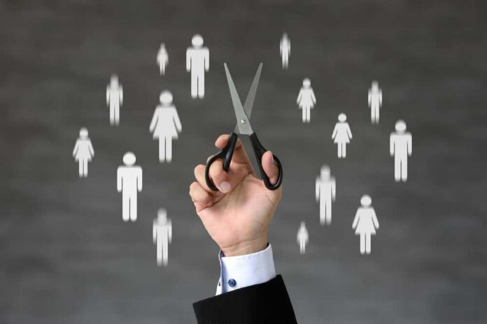 A hand holding scissors with icons of people in the background