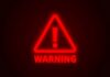 Red neon warning sign with an exclamation mark