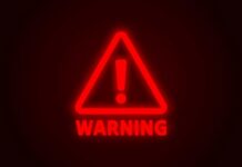 Red neon warning sign with an exclamation mark