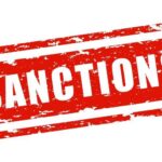 Red stamp with the word 'SANCTIONS' in bold white letters