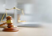 A wooden gavel and scales of justice on a desk