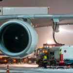 Ground crew fueling an aircraft during snowy weather