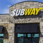 Exterior view of a Subway restaurant with a prominent sign