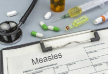 Medical supplies including a stethoscope, syringes, and medication related to measles