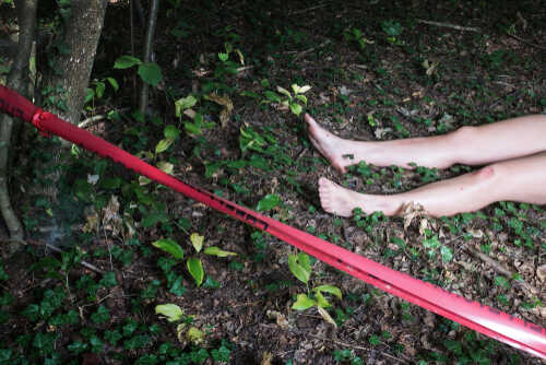Bare feet visible near caution tape in a wooded area