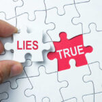 A hand holding a puzzle piece labeled 'LIES' next to a piece labeled 'TRUE'