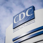 CDC building sign against a cloudy sky.