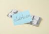 Blister pack of pills with a sticky note labeled 'abortion'