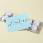 Blister pack of pills with a sticky note labeled 'abortion'
