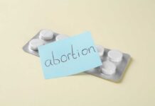 Blister pack of pills with a sticky note labeled 'abortion'