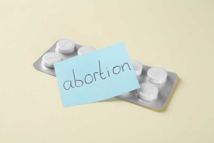 Blister pack of pills with a sticky note labeled 'abortion'