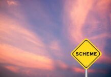 A yellow warning sign with the word 'SCHEME' against a colorful sky