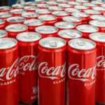 Coca-Cola cans stacked on a surface.