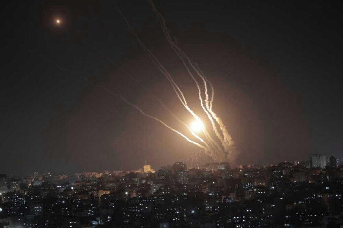 Night sky with rockets launching over a city.