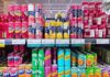 A variety of soda cans displayed on supermarket shelves
