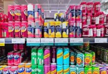 A variety of soda cans displayed on supermarket shelves
