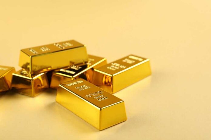 Several gold bars stacked on a golden surface