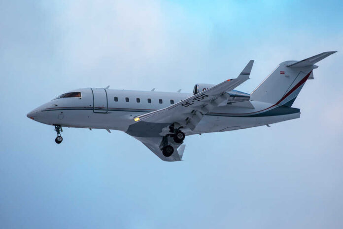 shutterstock_372147865.jpg A private jet approaching for landing against a cloudy sky