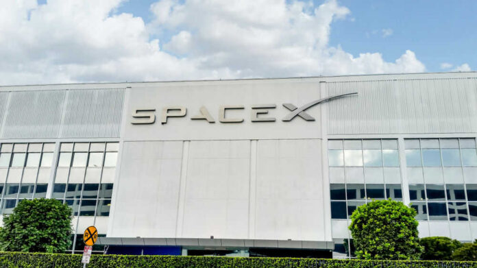 shutterstock_1458274766 SpaceX building with logo and blue sky.