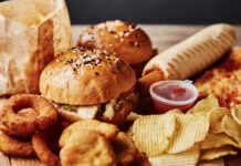 A variety of fast food items including burgers, onion rings, and chips