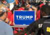 People holding Trump 2024 sign at a rally.