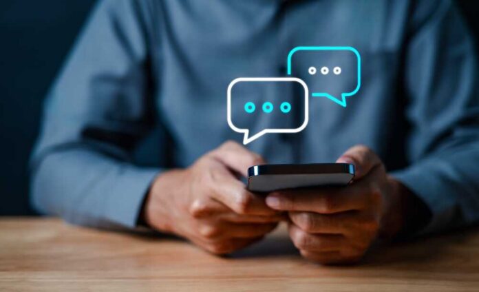 Person holding a smartphone with chat bubbles above