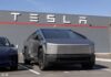 Tesla Cybertruck parked in front of a Tesla dealership