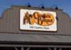 Sign for Cracker Barrel Old Country Store featuring a man sitting on a barrel