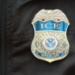 Close-up of an ICE officer badge on a black jacket