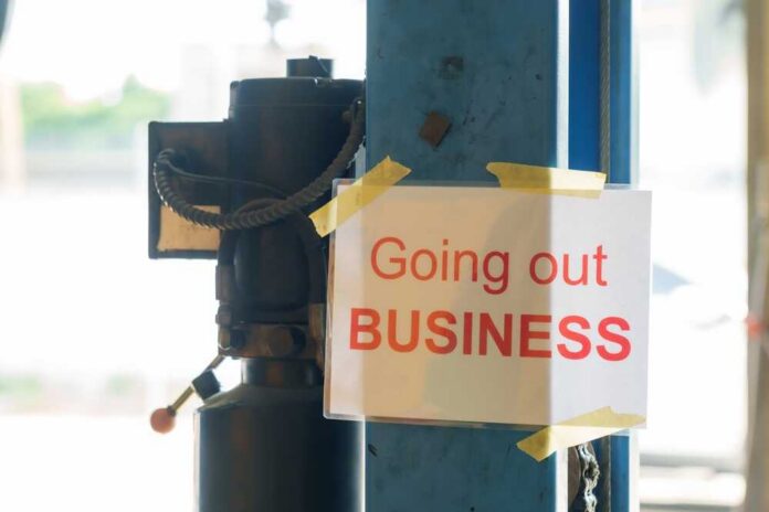 "going,Out,Of,Business",Sign,Taped,To,Metal,Pole,Inside Sign stating 'Going out of Business' attached to a pole