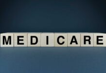 Wooden blocks spelling out MEDICARE on a dark background