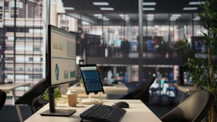 Computer monitor with analytics dashboard in a modern open office