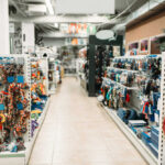 Pet store aisle with shelves of dog toys, leashes, and collars