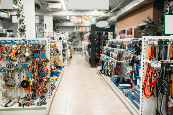 Pet store aisle with shelves of dog toys, leashes, and collars
