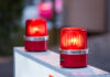 Two red warning beacons lit on a barrier