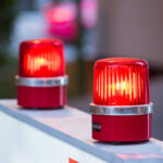 Two red warning beacons lit on a barrier