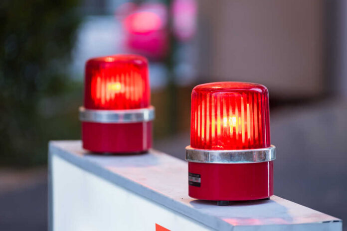 Siren,Red,Light,With,Soft-focus,In,The,Background Two red warning beacons lit on a barrier
