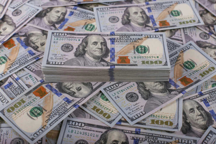 shutterstock_1257954658 Stack of one hundred dollar bills, Benjamin Franklins portrait.
