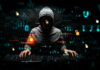 Hacker wearing a hoodie with digital codes overlaying.