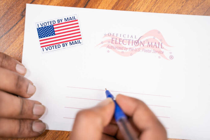 Hands addressing an official election mail envelope