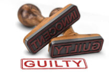 Two rubber stamps labeled guilty and innocent on a white surface